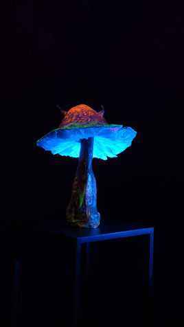 Eine leuchtende Pilz Skulptur aus Recyclingmaterial im UV-Licht